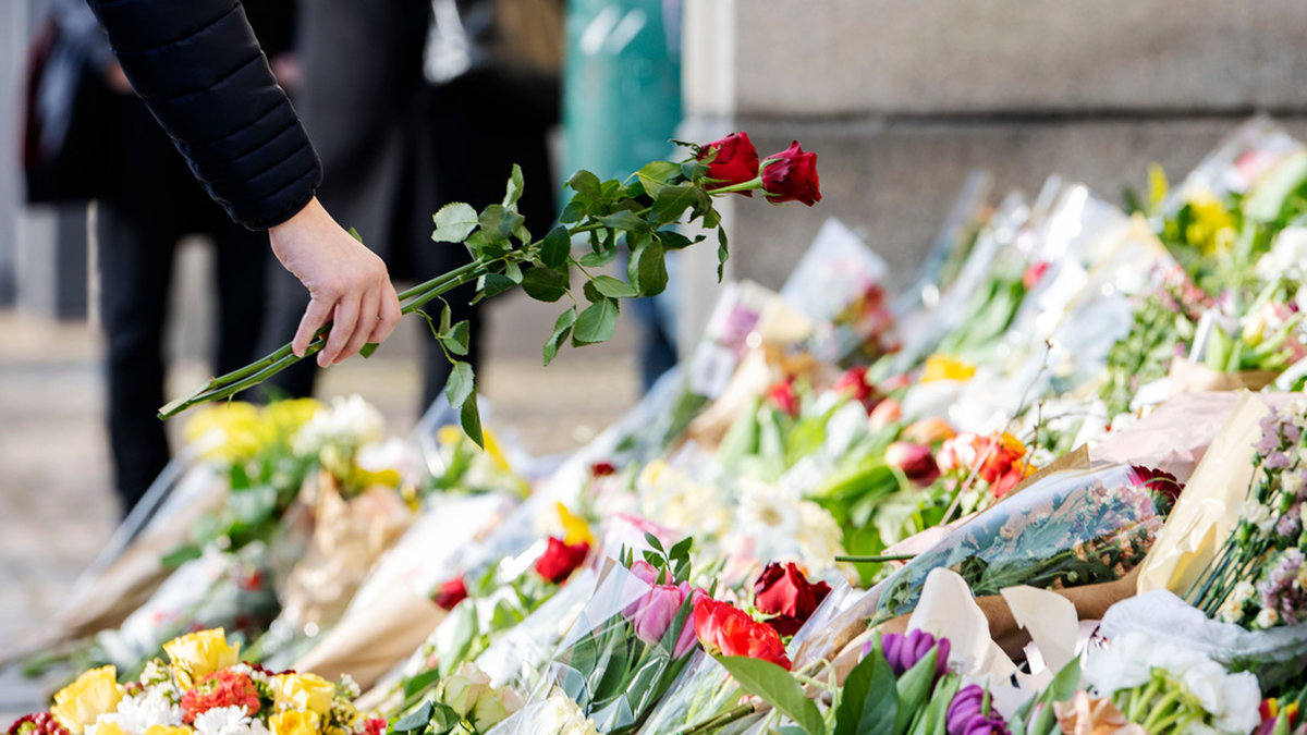 Rosor placeras i havet av blommor och ljus på trappan vid huvudentrén på Malmö Latinskola den 22 mars, dagen efter att två av skolans lärare dödats av en elev. Arkivbild.