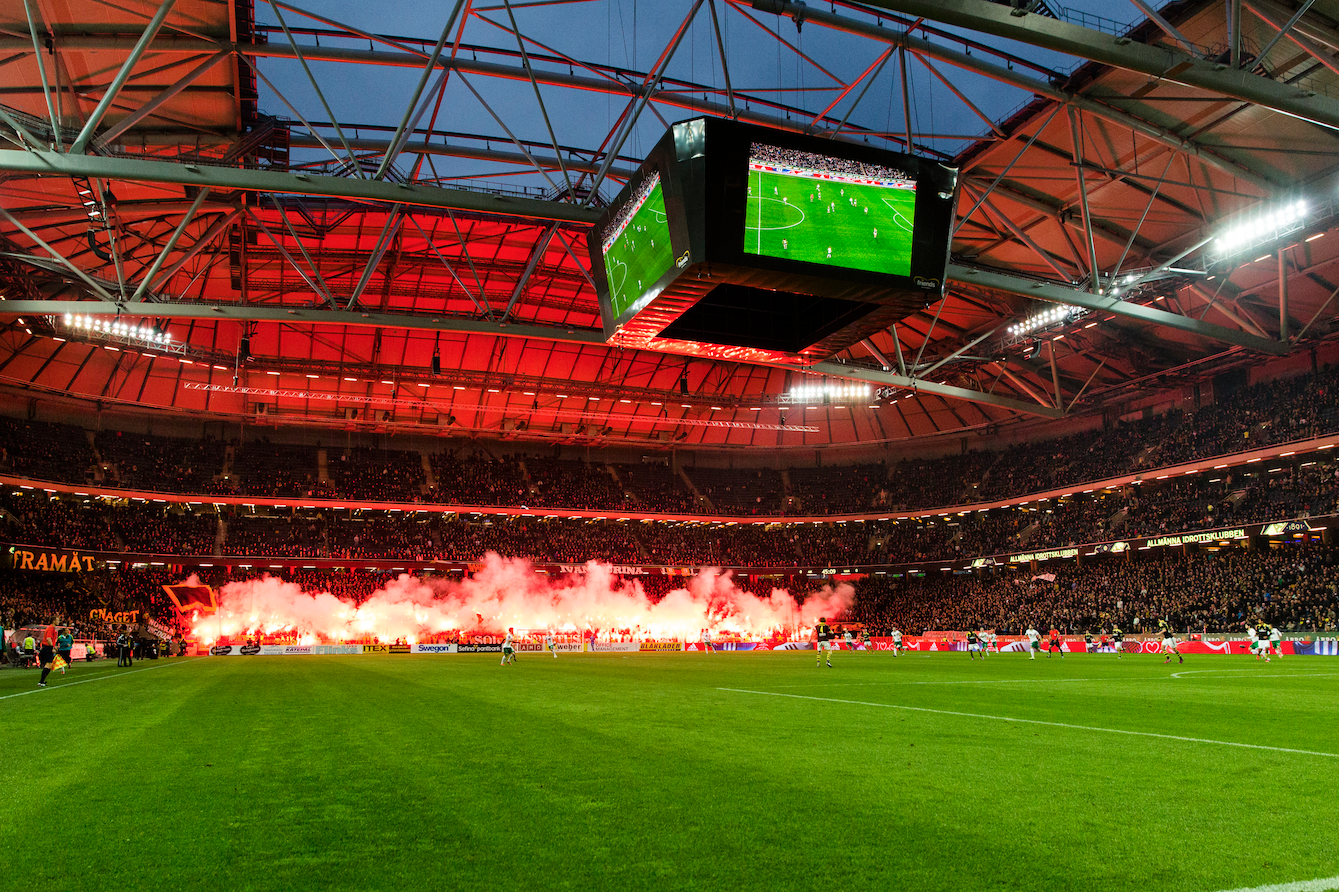 AIK-supportrarnas bengaler lyser upp Friends Arena. AIK-supportrarnas bengaler lyser upp Friends Arena.