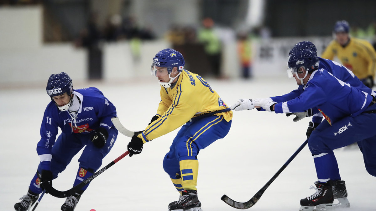 Sveriges Erik Säfström stoppas av Finlands Markus Kumpuoja och Elias Gillgren under det senaste världsmästerskapet i bandy - 2019 i Vänersborg.