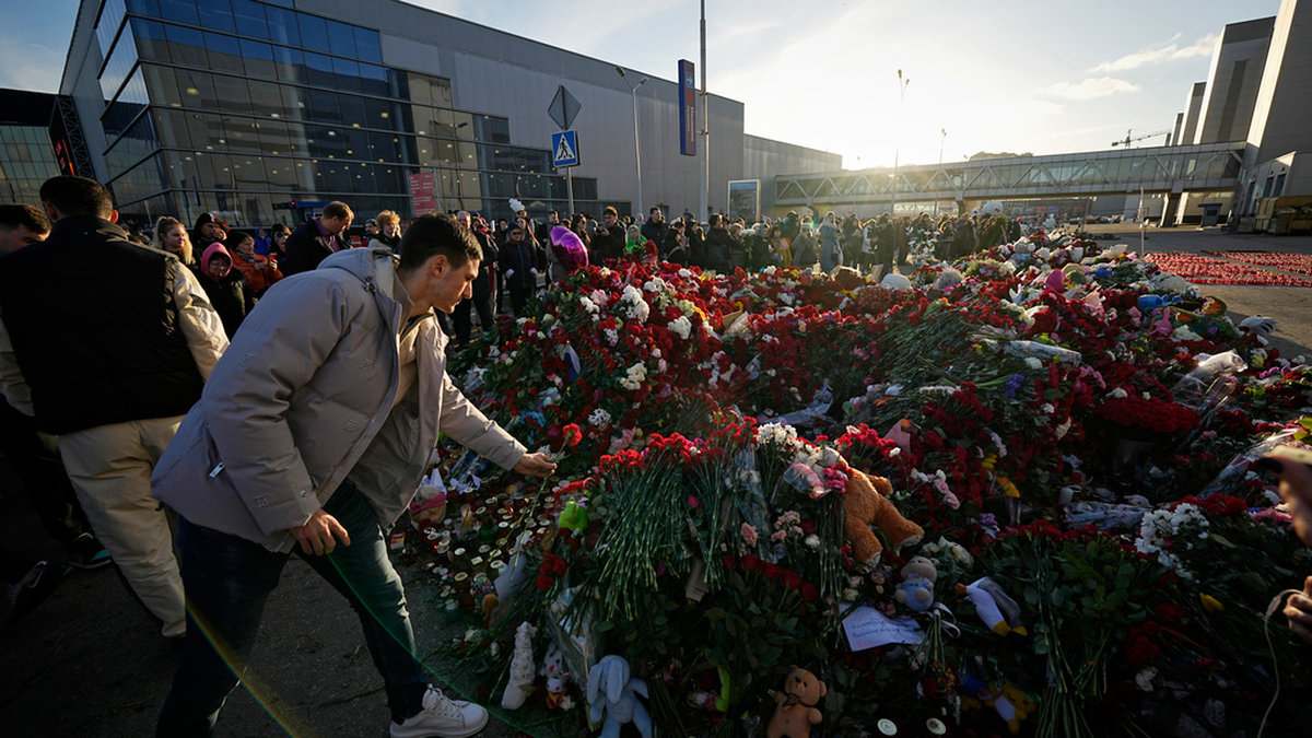 Sörjande människor lägger ner blommor vid Crocus City Hall i Moskva.
