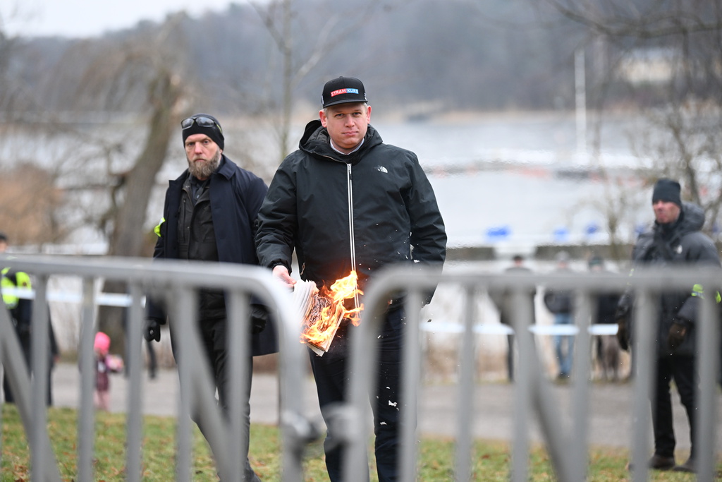 Den högerextreme politikern Rasmus Paludan bränner ett exemplar av muslimernas heliga bok i närheten av Turkiets ambassad i samband med en allmän sammankomst i januari. Arkivbild.