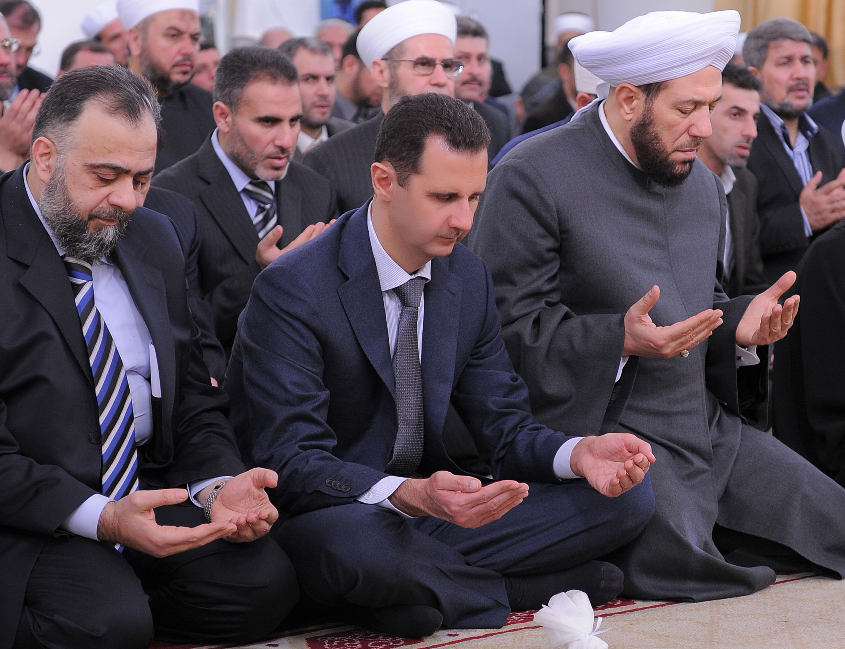 Assad lever ett lyxliv medan tusentals syrier svälter och dör. Bashar al-Assad sitter i mitten. Assad lever ett lyxliv medan tusentals syrier svälter och dör. Bashar al-Assad sitter i mitten.