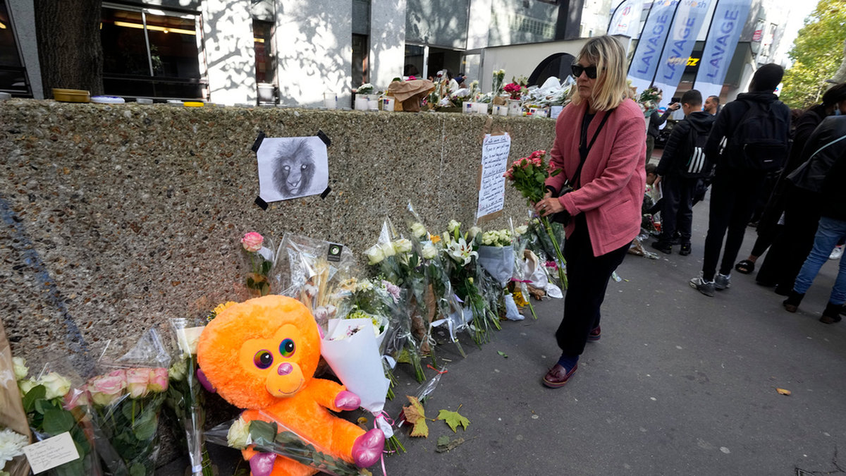 En kvinna lägger blommor utanför det lägenhetshus i Paris där 12-åriga Lola hittades mördad. Arkivbild från i onsdags förra veckan.