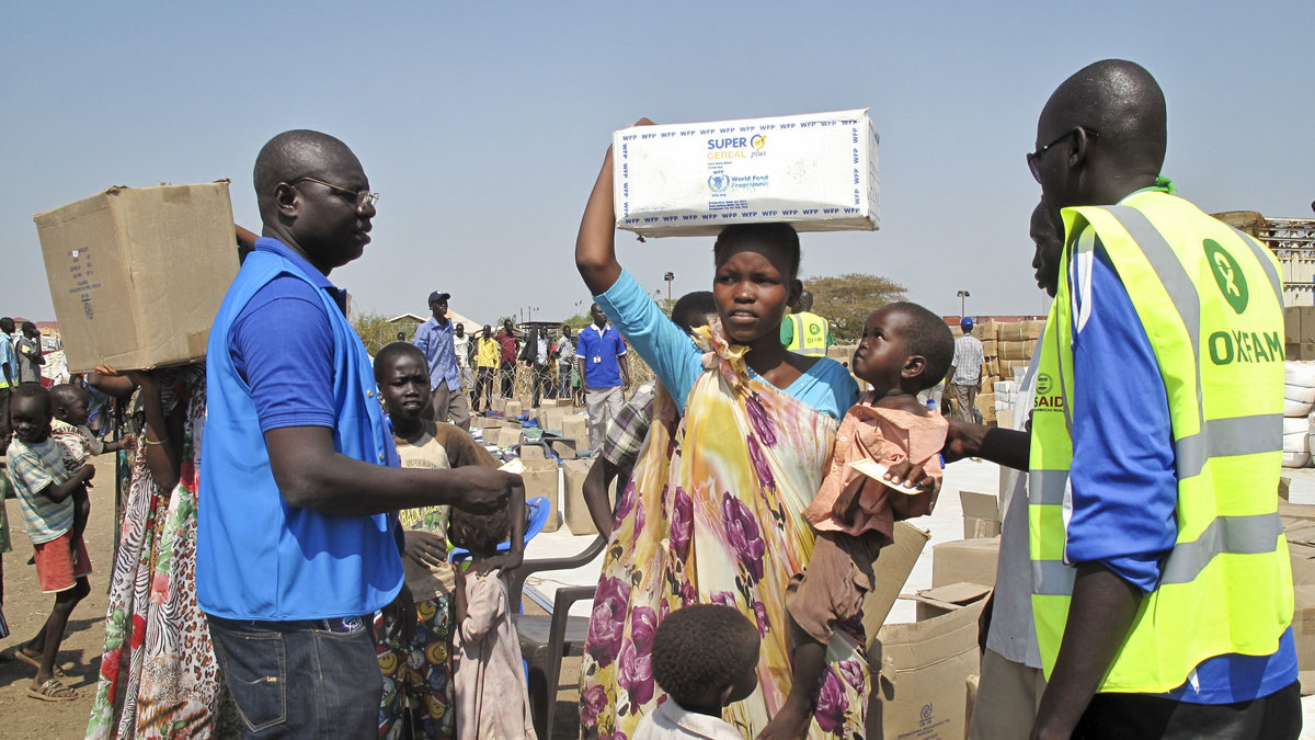 En hjälparbetare från Oxfam delar ut mat till en kvinna i ett FN-läger i Sudan.