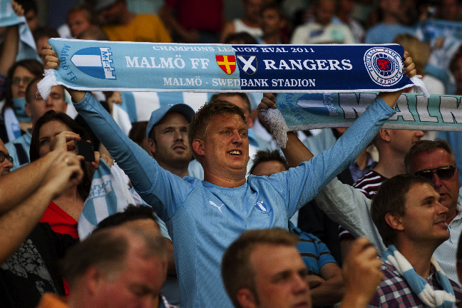 En glad MFF-supporter visar upp den felstavade "Champions Leauge"-halsduken. En glad MFF-supporter visar upp den felstavade "Champions Leauge"-halsduken.