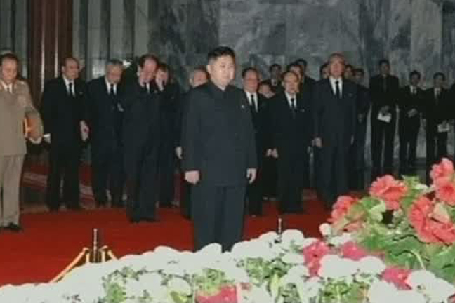 Nordkoreas näste ledare Kim Jong-Un framför kistan.