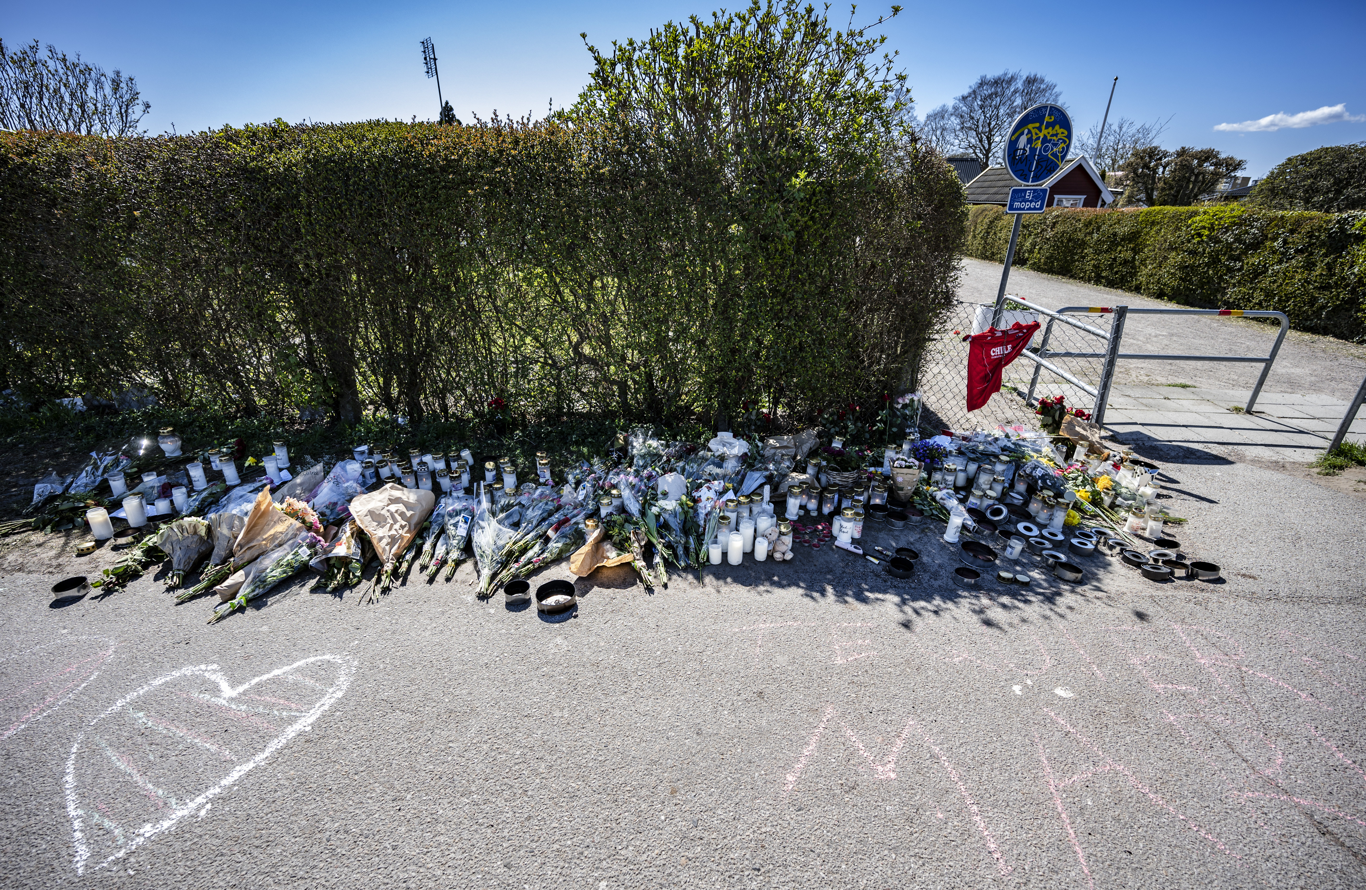 Blommor, ljus och meddelanden på platsen där 18-åringen hittades mördad.