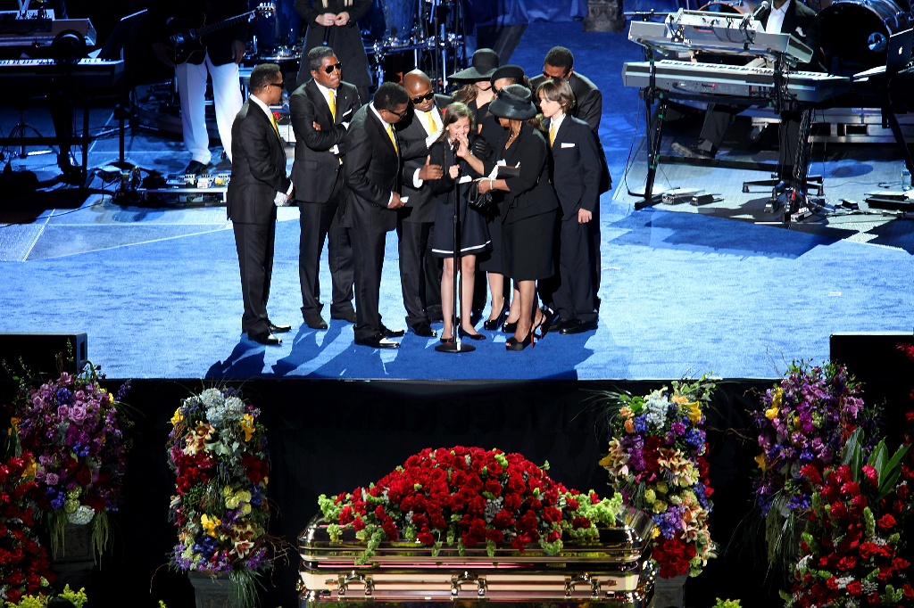 Barnen på scen med släktingar när Michael Jackson begravdes. 